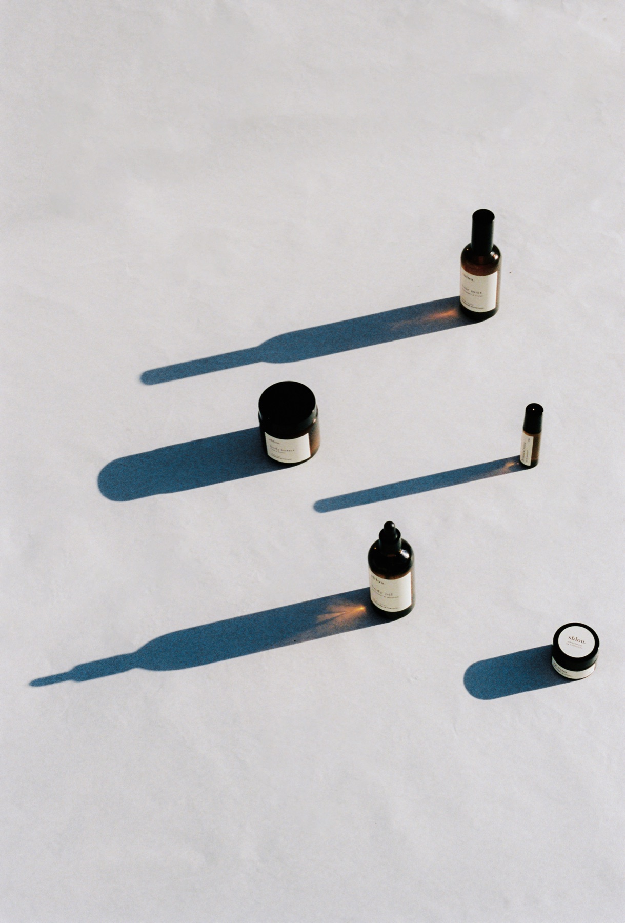 The shlou collection laid out on warm paper, long afternoon shadows